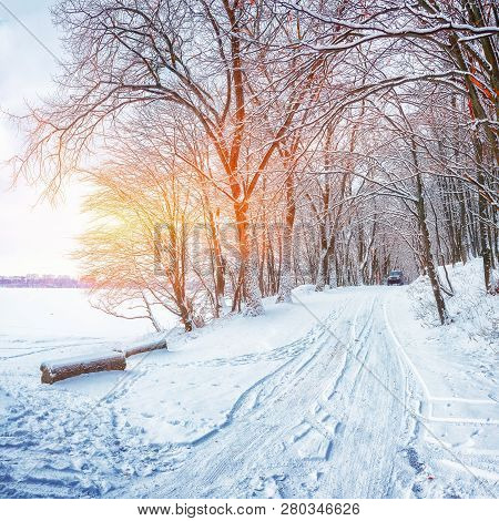Single Car On A Winter Road In The Forest. Lots Of Snow At Sunset