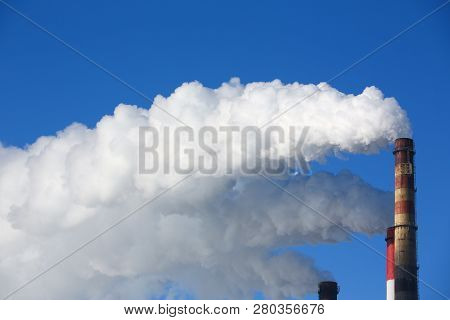 White Smoke Comes From Pipes Against Blue Sky. Problem Harmful Emissions And Air Pollution Of Centra