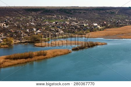 River Flowing Between Hills And The Village In Rural Areas. Landscape