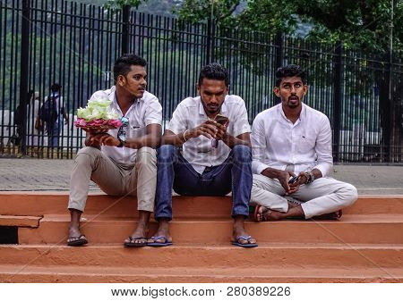 Kandy, Sri Lanka - Dec 15, 2018. Local Young Men Sitting At Temple Of The Sacred Tooth Relic In Kand