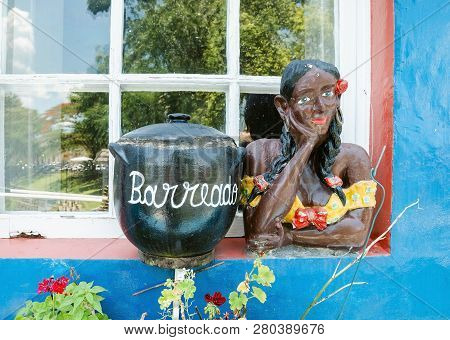 Morretes - Pr, Brazil - December 17, 2018: Sculptures That Has A Pan Illustrating The Barreado, A Ty