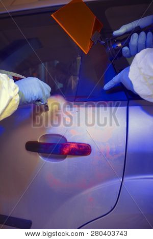 Crime Investigation - Developing Of Fingerprints On Suspected Car In Police Garage Under Uv Light