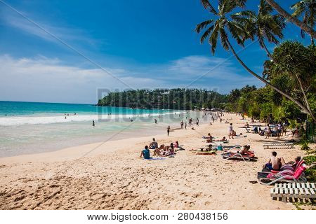 Mirissa Beach, Sri Lanka - JAN 2, 2017:  Tourists walking on the sand while enjoying the view across the wonderful beach of Mirissa on Jan 2, 2017. Sri Lanka.
