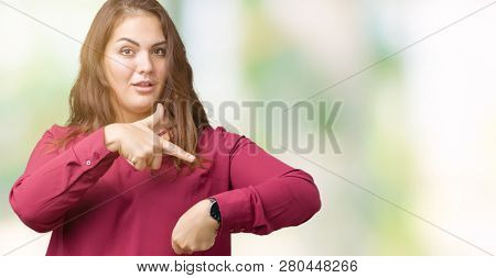 Beautiful plus size young woman over isolated background In hurry pointing to watch time, impatience, upset and angry for deadline delay