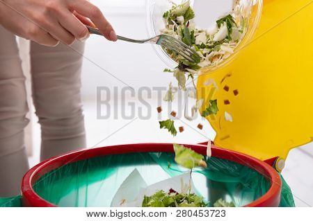 Woman Throwing Vegetables In Trash Bin