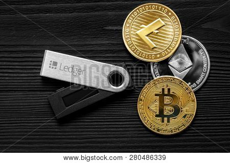UKRAINE, ROVNO - ON JANUARY 23: Ledger hardware wallet for cryptocurrency on a wood background