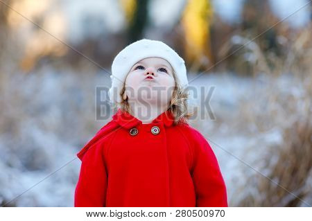 Outdoor Winter Portrait Of Little Cute Toddler Girl In Red Coat And White Fashion Hat Barret. Health