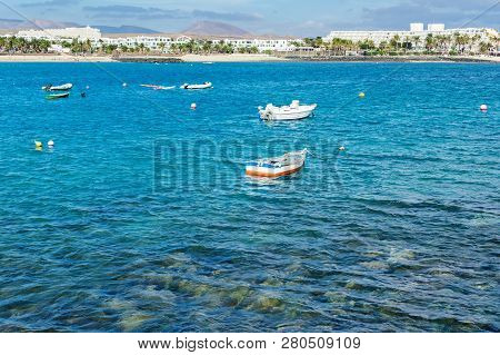 View Of Playa De Las Cucharas Beach In Costa Teguise, Lanzarote, Spain, Turquoise Waters, Boats, Sel