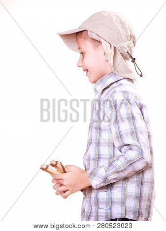 Nature And Free Time Prankster Little Boy. Child Have Fun With  Wooden Sling Shot And Fruit Hold Man
