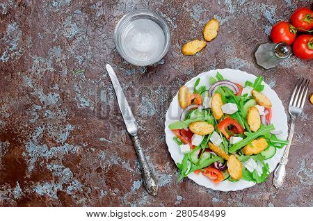 Fresh  Green Salad With Cucumber, Arugula,  Soft Cheese And Crackers On A Dark Table. Healthy Food L