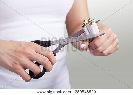 Quit Smoking. Closeup Of Womens Hands Holding A Bunch Of Cigarettes And Cutting Them In Half Scissor