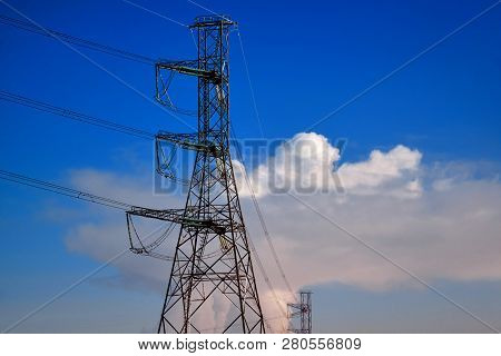 A Transmission Tower Or Electricity Pylon With Blue Sky. It Is A Tall Structure, Usually A Steel Lat