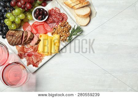 Flat Lay Composition With Wine, Snacks And Space For Text On White Background