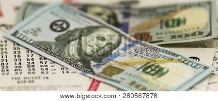 Two One Hundred Dollar Bills On Top Of Many Receipts For Lottery Tickets.