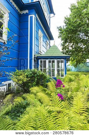 Garden Scenery Of Blue Wooden Old House With Alive Plants Flowers And Trees With Leaves On A Sprong 