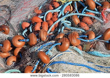 Close Up Background Of Heap Coils Of Sea Fishing Net With Colorful Vivid Floats And Cable Ropes At H