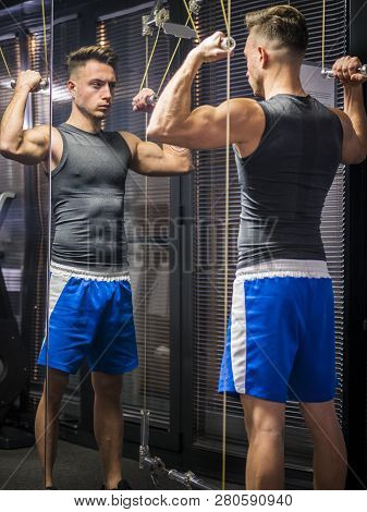 Muscular Young Man, Training Shoulders On Gym Machine