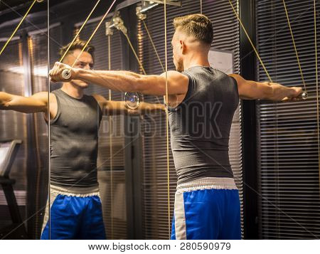 Muscular Young Man, Training Shoulders On Gym Machine