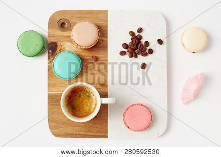 Macaroons and a cup of coffee. Colorful french macaroons with coffee on a white table. 