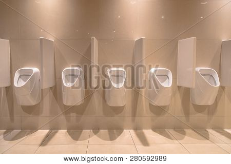 Row Of Modern Urinals In New Bathroom Of Theater
