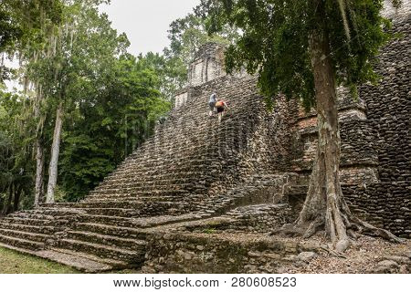 A couple climbs the steps of the Mayan temple of Dzibanche along the Mexico, Belize border.