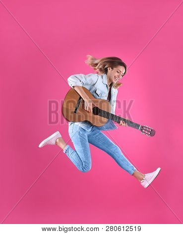 Young Woman Playing Acoustic Guitar On Color Background