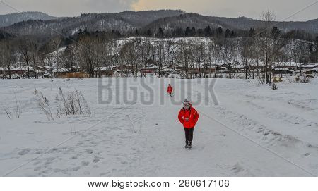 Woman Walking At Snow Village In China