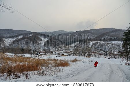 Woman Walking At Snow Village In China
