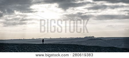 Lone Hiker On The Ridgeway Trail Across Barbury Castle, Swindon, Wiltshire, Uk