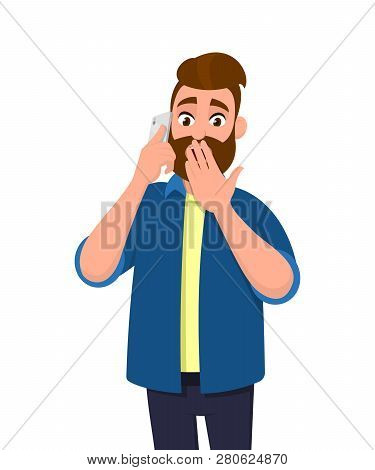 Young Man Is Talking On The Cell Phone With Shocking Expression. Bearded Man Holding Hand On Mouth W