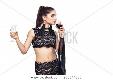 Young Gorgeous Girl Holds A Glass Of Champagne And Drinks Wine. Isolated On White