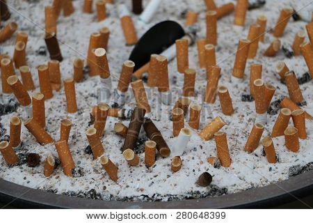 Metallic Ashtray With Cigaretts In The Sand