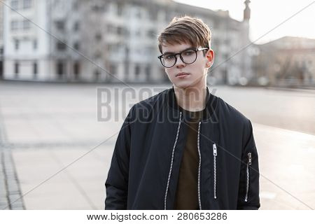 Portrait Of An Attractive Young Hipster Male In Glasses With A Fashionable Hairstyle In Stylish Oute