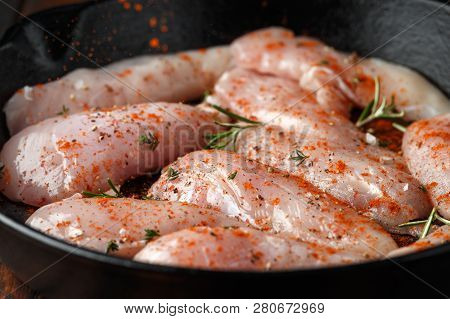 Raw Chicken Breast Mini Fillets In Rastic Cast Iron Skillet, Frying Pan With Herbs And Sea Salt