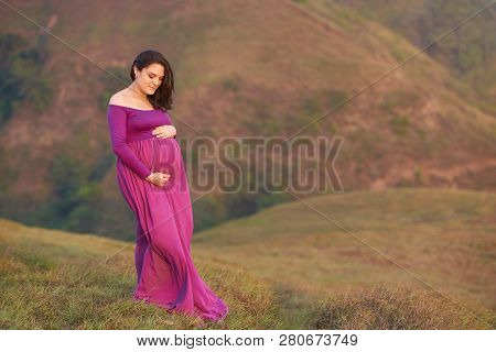 Pregnat Woman Hugging Belly On Natural Background