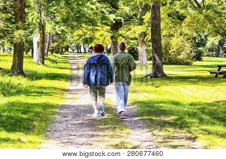Litchfield, Connecticut.  September 9, 2017.  A Grandmother And Granddaughter Holding Hands Walking 