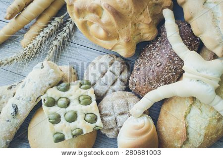Assortment Of Traditional Italian Freshly Baked Crusty Loaves Of Bread And Buns With Ears On Wooden 