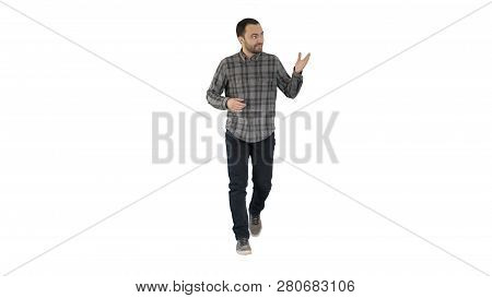 Young Confident Man In Shirt And Jeans Walking Towards Camera And Pointing To The Sides On White Bac