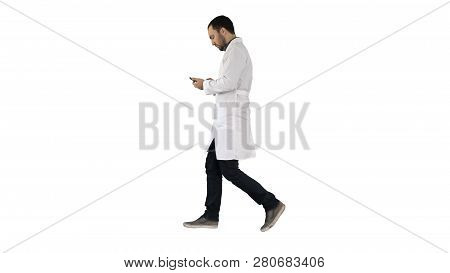 Male Doctor Walking And Using Mobile Phone On White Background.