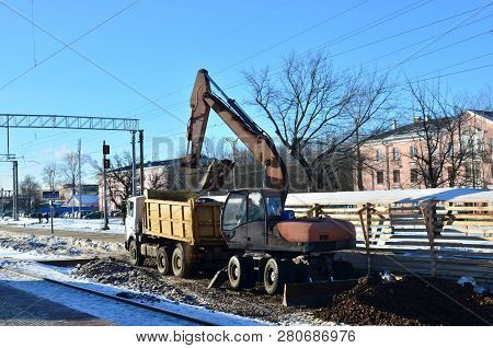 The Excavator Loads Crushed Stone In A Dump Truck Body. Construction Of The Railway. Preparing The S