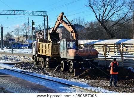 The Excavator Loads Crushed Stone In A Dump Truck Body. Construction Of The Railway. Preparing The S