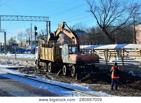 The Excavator Loads Crushed Stone In A Dump Truck Body. Construction Of The Railway. Preparing The S