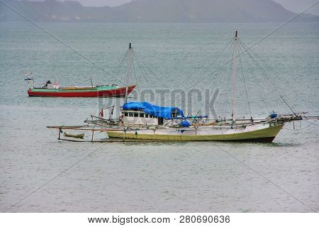 Traditional Outrigger Boat Anchored At Labuan Bajo Town On Flores Island, Nusa Tenggara, Indonesia. 
