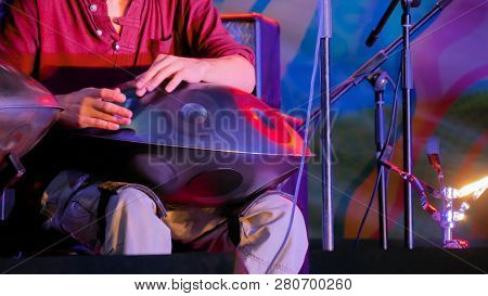 Man Playing Tank Drum Or Hang On Stage Of Ethnic Open Air Concert. Relaxation, Folk, Meditative And 