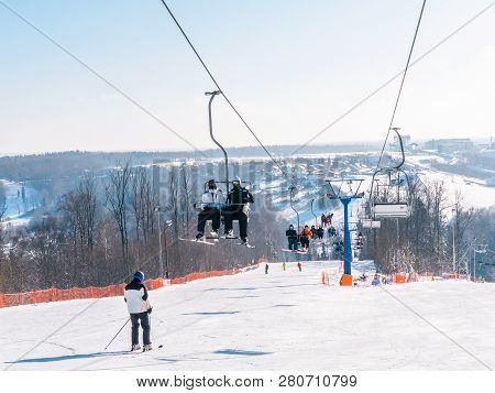 Skiers And Snouborders On A Ski Lift Pov In Winter Time. The Cable Car Lifts The Peoples Up To The S