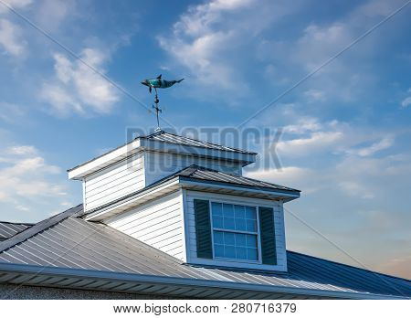 An Old Dolphin Windvane On A Wood And Copper Cupola On Old Building
