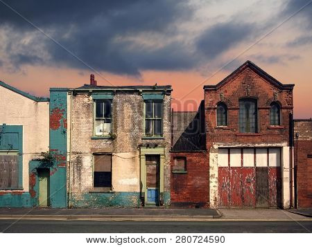 A Deserted Street Of Old Abandoned Ruined Houses With Bright Peeling Paint And Crumbling Brickwork I