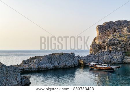 This Is A Picute Of A Sailboat Achored In A Secluded Greek Harbour.