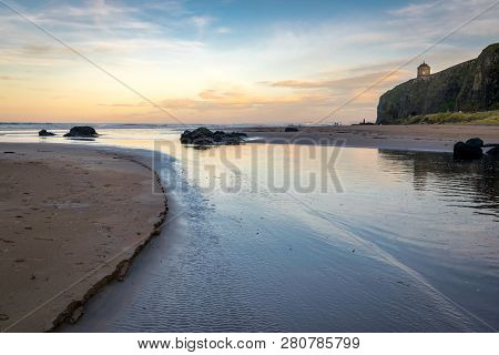 This Is A Curving Stream That Runs Into The Ocean At Benone Beach In Northern Ireland.  The Picture 