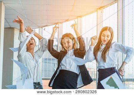Three Young Beautiful Brunette Business Ladies In The Office. All Happy Dancing Dancing Up The Docum
